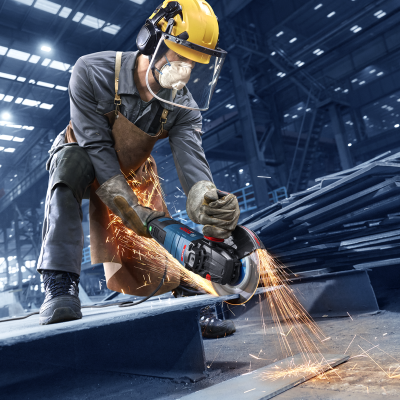 Trabalhador industrial equipado com proteção a usar rebarbadora BOSCH azul e preta numa fábrica