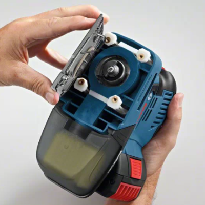 Ferramenta elétrica azul e preta com tampa aberta, segurada por mãos, em fundo branco