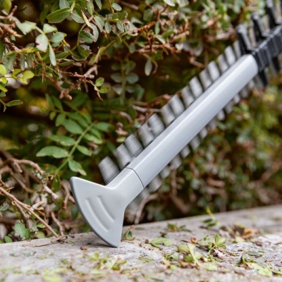 Tesoura de poda cinzenta e preta a cortar ramos de arbusto