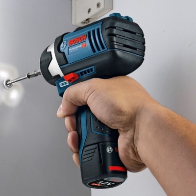 Parafusadora a bateria Bosch GSR 12V-15 a ser usada em superfície branca perfurada