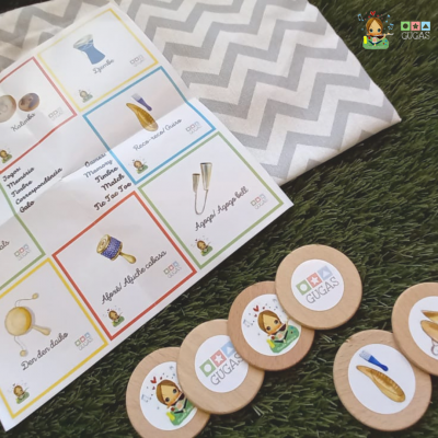 Jogo educativo com cartões e fichas de madeira sobre tecido cinza com padrão zig-zag