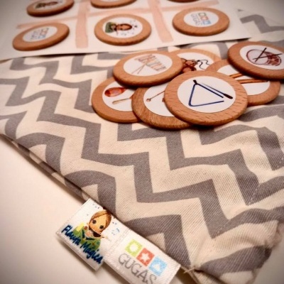 Jogo de peças de madeira ilustradas sobre tecido cinza com padrão em ziguezague branco