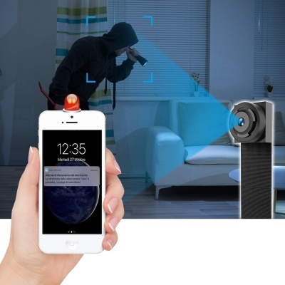 smartphone branco com alerta de deteção de movimento e câmera de vigilância a captar ladrão junto a sofá