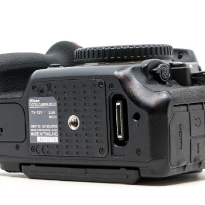 Câmara digital Nikon preta vista de baixo com etiquetas e portas
