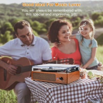 Gira-discos vintage de madeira sobre mesa numa cena ao ar livre com pessoas ao fundo