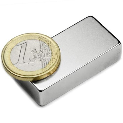 Bloco metálico prateado com moeda de 1 euro em cima, fundo branco