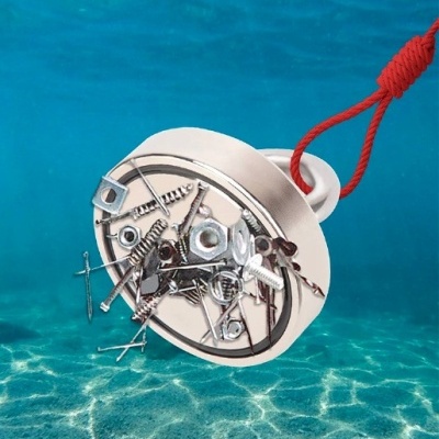 Imã redondo prateado com cordão vermelho atraindo pregos e parafusos submerso em água