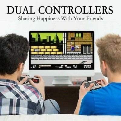 Dois jovens jogam videojogo retro num computador branco com comandos pretos.