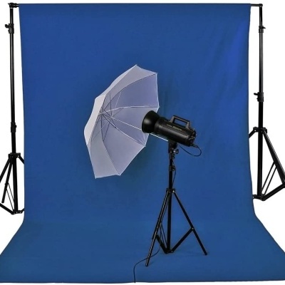 Conjunto equipamento fotografia com fundo azul, tripé, luz de estúdio e guarda-chuva branco