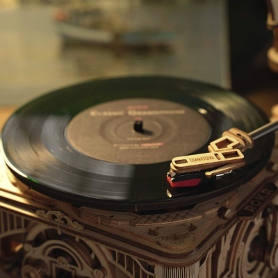 Gira-discos clássico de madeira a tocar disco vinil preto
