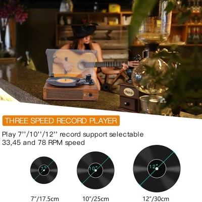 Gira-discos de madeira retro com disco vinil no balcão e pessoa tocando guitarra ao fundo