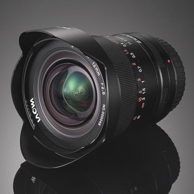 Objetiva fotográfica preta com texto 12mm F2.8 LAOWA e marcas de distância