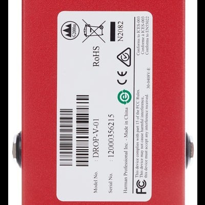 Parte inferior de pedal de efeito musical vermelho com etiqueta branca e bases antiderrapantes pretas.