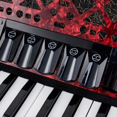 Close-up de botões e teclas pretas e brancas de acordeão vermelho marmoreado