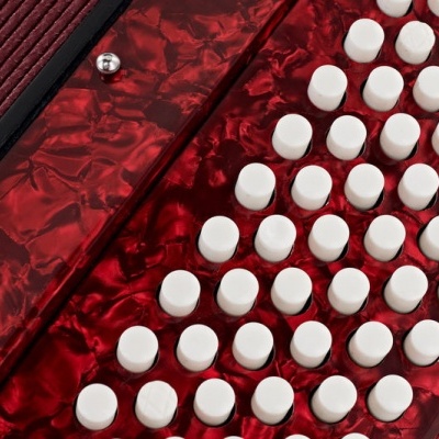 Acordeão vermelho com botões brancos e acabamento marmoreado