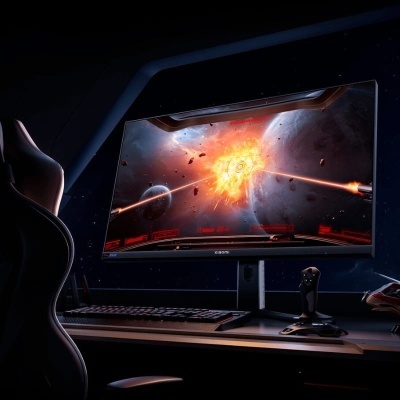 Monitor curvo Iiyama a mostrar jogo espacial numa secretária com teclado, joystick e cadeira gaming