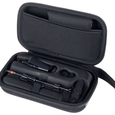 Estojo preto rígido aberto com dispositivo circular com cabo, clipe e suporte anel acolchoados interiormente