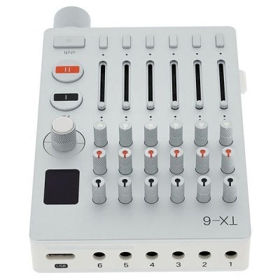 Mesa de mistura de áudio branca com controlos deslizantes cinzentos e botões rotativos