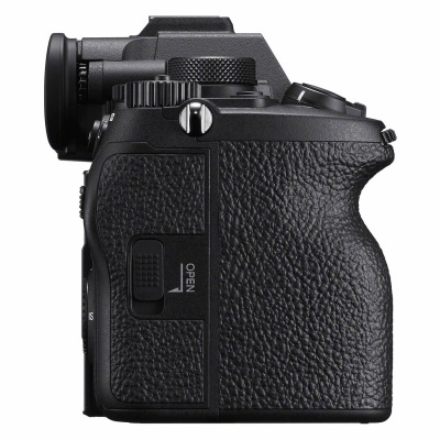 Câmara fotográfica digital preta com textura rugosa e botão OPEN na lateral