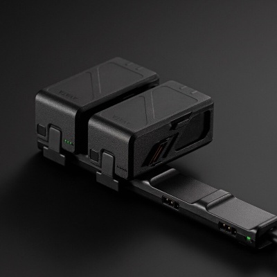 Dispositivos eletrónicos pretos conectados a um cabo USB sobre fundo preto