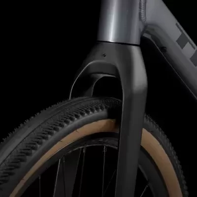 Roda dianteira de bicicleta preta com aro castanho e texto TREK no quadro