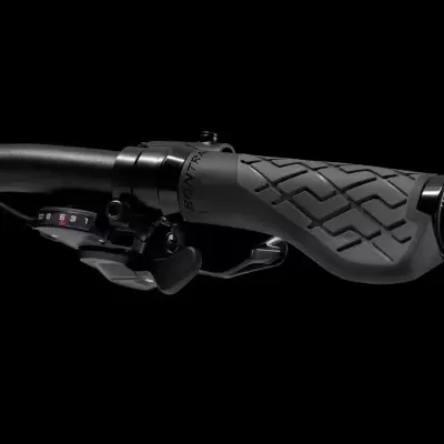 Punho direito de guiador de bicicleta com manete de travão e controlo de velocidades preto sobre fundo preto.