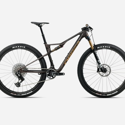 Bicicleta de montanha preta com detalhes em cobre e pneus Maxxis