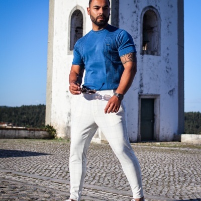 Homem com roupa casual exclusiva em frente a edifício branco antigo