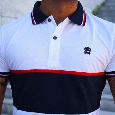 Polo masculino tricolor branco, azul escuro e vermelho com gola e botão azuis escuros.