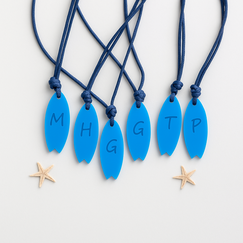Seis colares com pendentes azuis em forma de prancha de surf e letras, com cordões azuis sobre fundo branco e duas estrelas-do-mar.