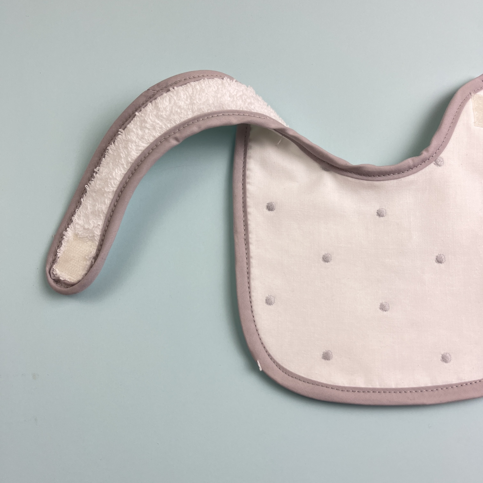 Babete para bebé branco com pontos cinzentos e bordas lilás