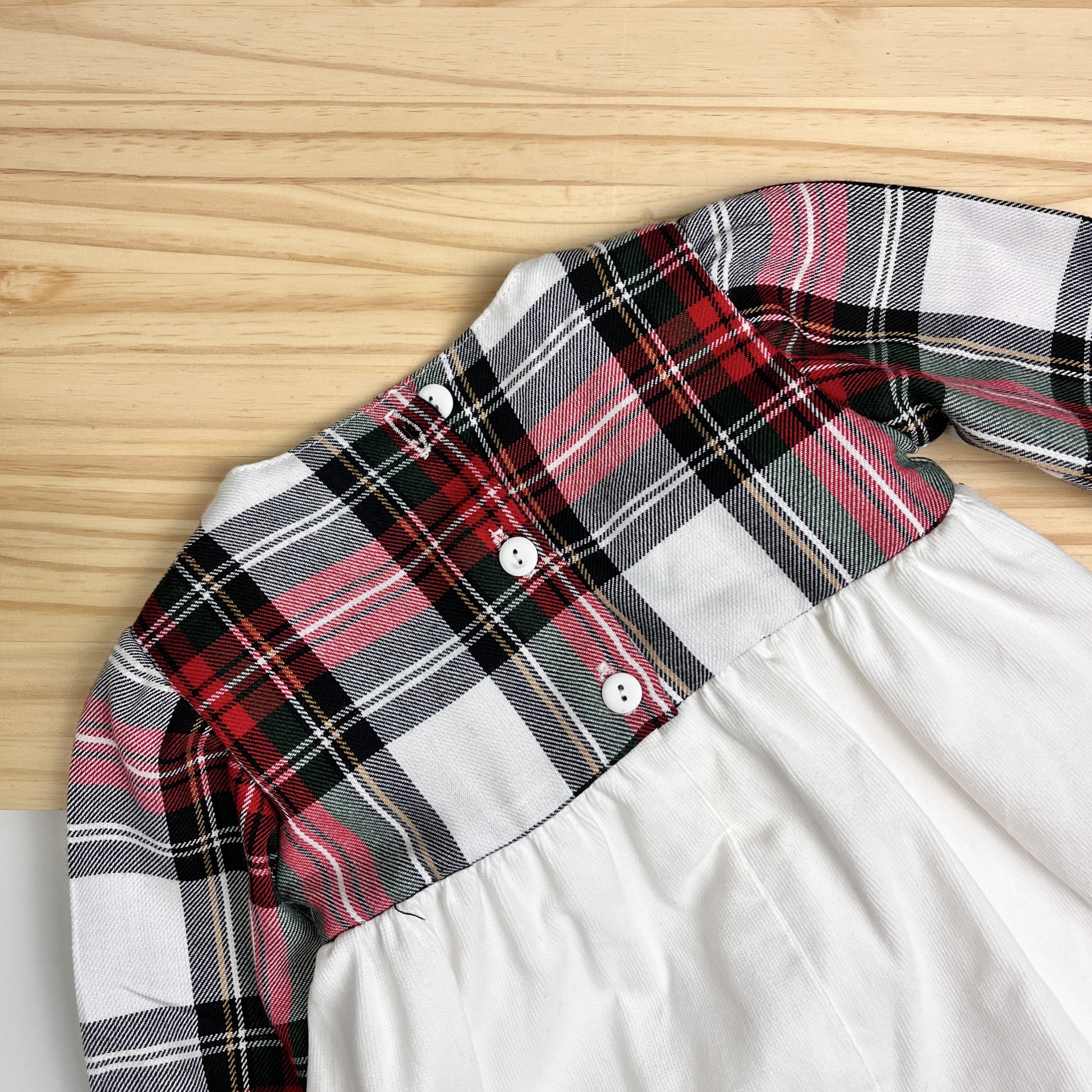 Vestido de bebé xadrez vermelho e branco em madeira