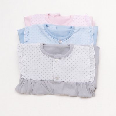 Peúgas de bebé rosa, azul e cinza com bolinhas empilhadas sobre fundo branco