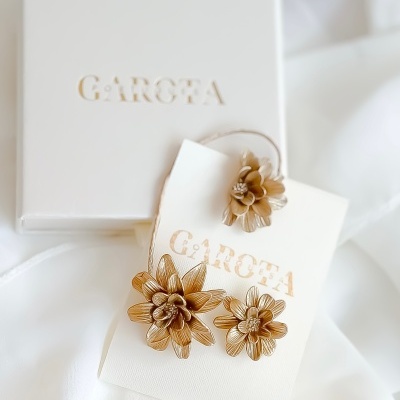 Conjunto de joias douradas florais com embalagem branca