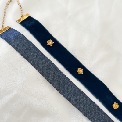 Dois colares tipo choker azul escuro e azul claro com fecho dourado sobre tecido branco