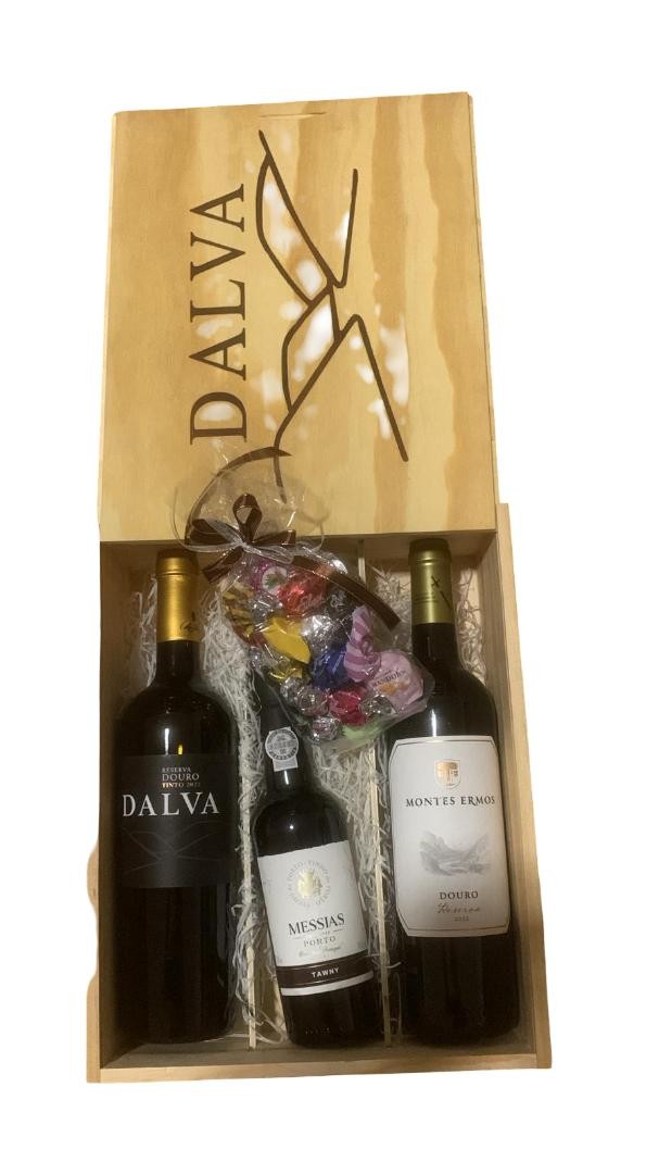 Caixa de madeira com três vinhos e saco de doces coloridos