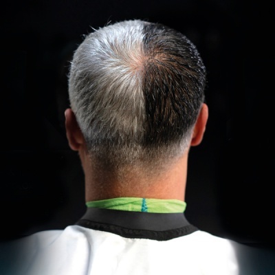 Traseira da cabeça com cabelo dividido em branco e castanho, capa de barbeiro branca