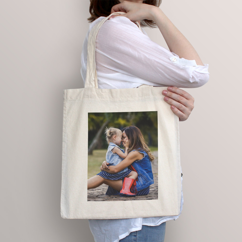 Sacola de tecido creme com impressão de mulher e menina sentadas ao ar livre