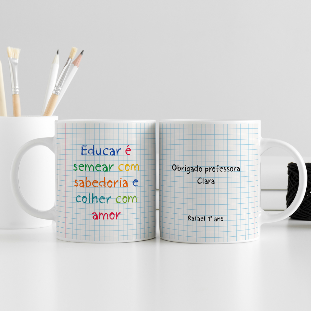 Duas canecas brancas quadriculadas com textos coloridos e pretos sobre agradecimento a professora, sobre mesa branca com pincéis e bola de linha.