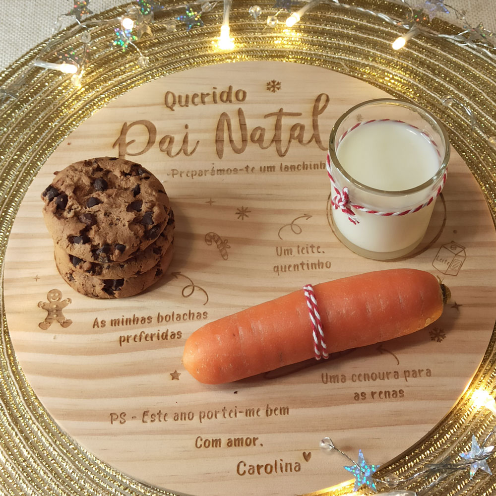 Tabuleiro de madeira com bolachas, copo de leite e cenoura para o Pai Natal, decorado com luzes e detalhes dourados