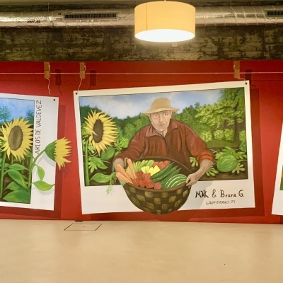 Painéis com ilustrações de girassóis, agricultor com legumes e banca de mercado