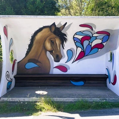 Abrigo de autocarro com mural de cavalo e coração colorido
