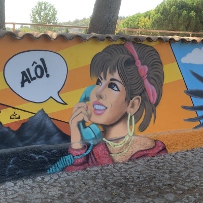 Mural colorido de mulher a falar ao telefone antigo com texto ALÔ!