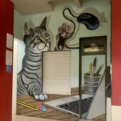 Grafite de gato cinza e rato de computador numa parede e porta pintadas com objetos de escritório.