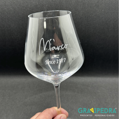 Taça de vinho de vidro com escrita branca 'Marco since 1977'