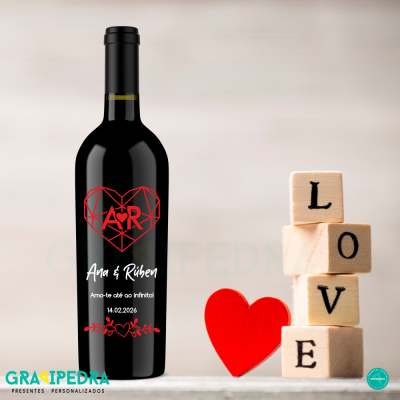 Garrafa de vinho personalizada com coração vermelho e texto Ana & Rúben, ao lado blocos de madeira com a palavra LOVE e coração vermelho