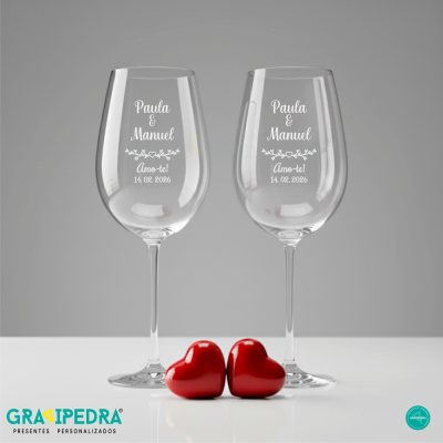 Dois copos de vidro transparentes com texto branco e dois corações vermelhos