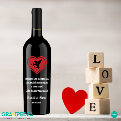 Garrafa de vinho personalizada em preto com texto em português e coração vermelho, ao lado blocos de madeira com LOVE e coração de madeira vermelho.