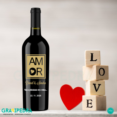 Garrafa de vinho preta personalizada com rótulo AMOR, nomes e data, ao lado blocos de madeira com letras LOVE e coração vermelho