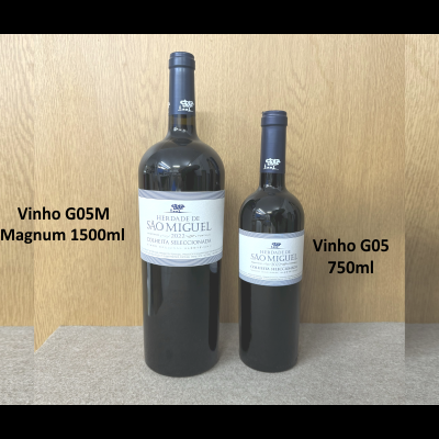 Duas garrafas de vinho São Miguel, uma Magnum 1500ml e outra 750ml, sobre superfície cinza e fundo de madeira.